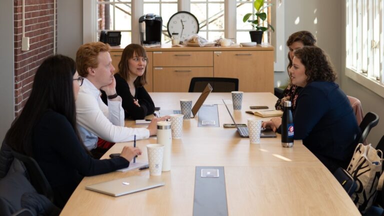 Members of the newsroom participate in a staff meeting.