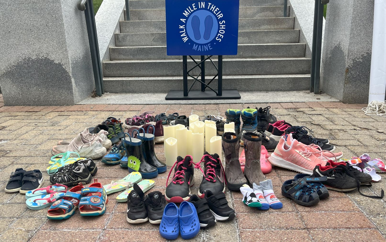 A pile of children's shoes in front of the podium at the rally.