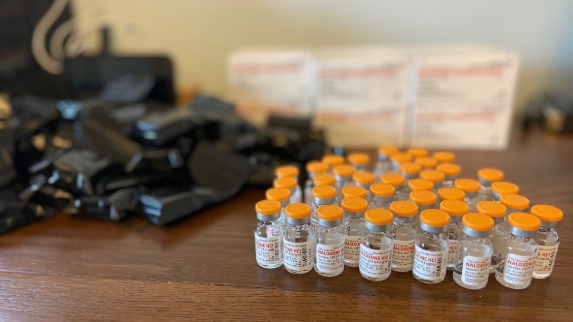 Bottles of intramuscular naloxone sit on a table.