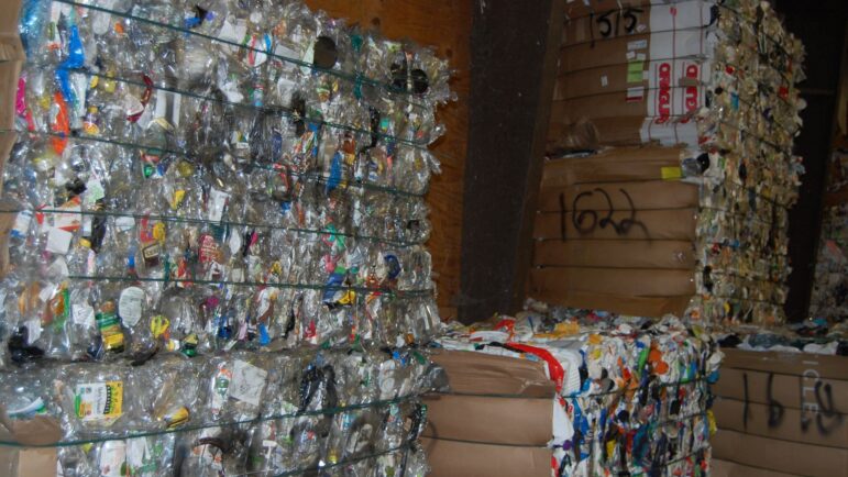 Pallets of bundled recycled plastic material.