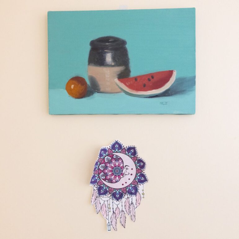 Two hand-made art pieces hang on a wall.