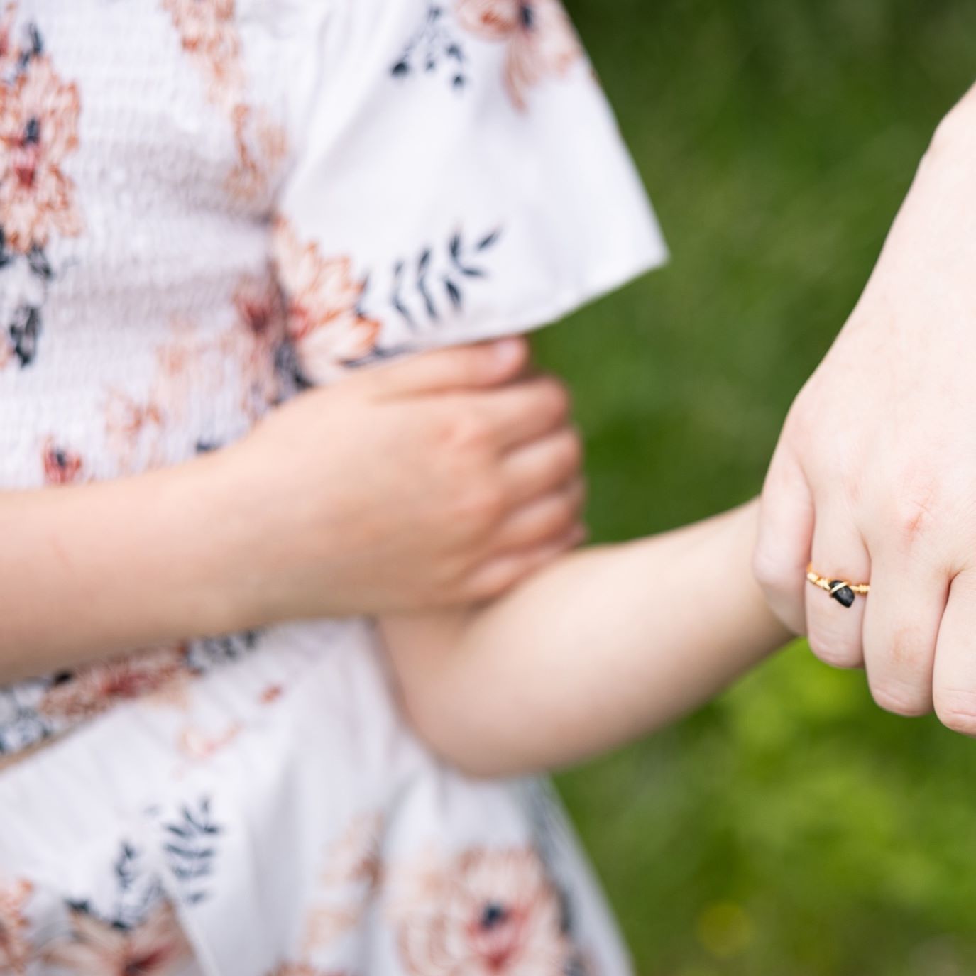 A younger girl has her hand being held by her mother.