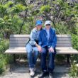 Two women sitting on a park bench.