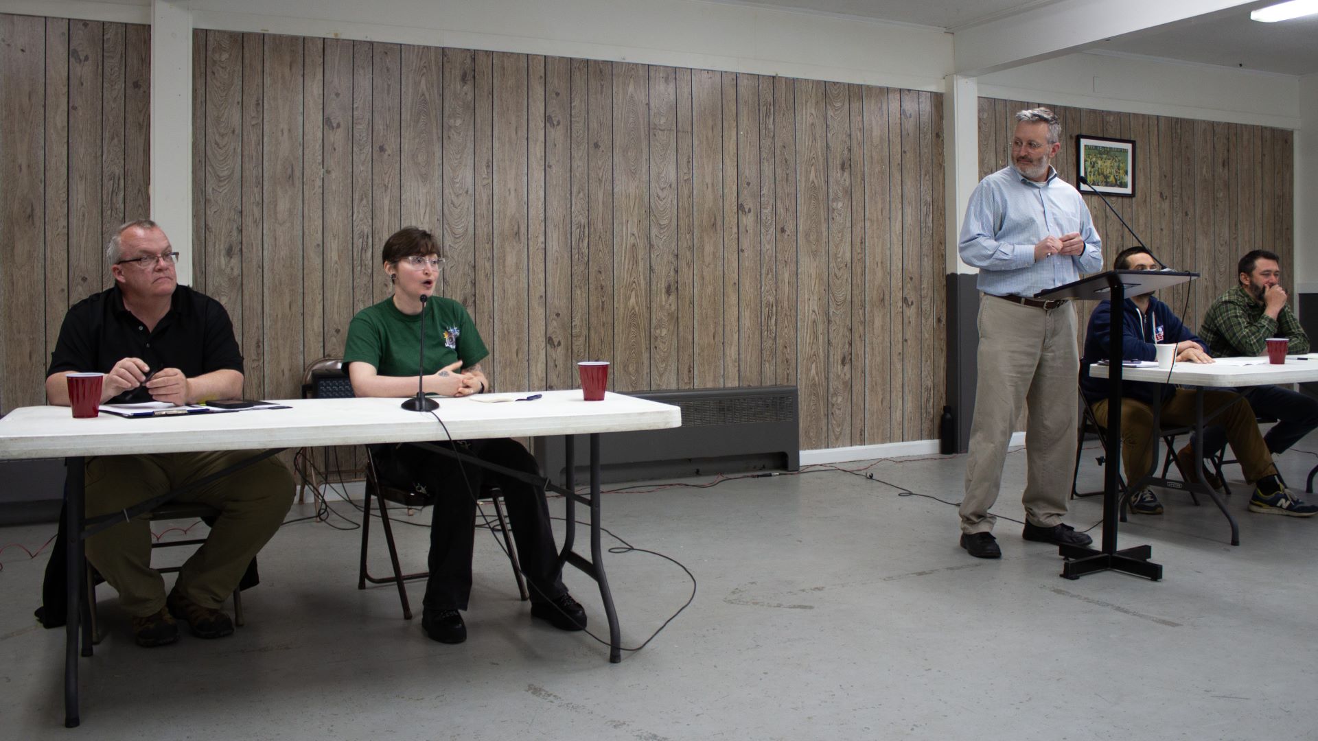 A trio of speakers at the front of the meeting room.