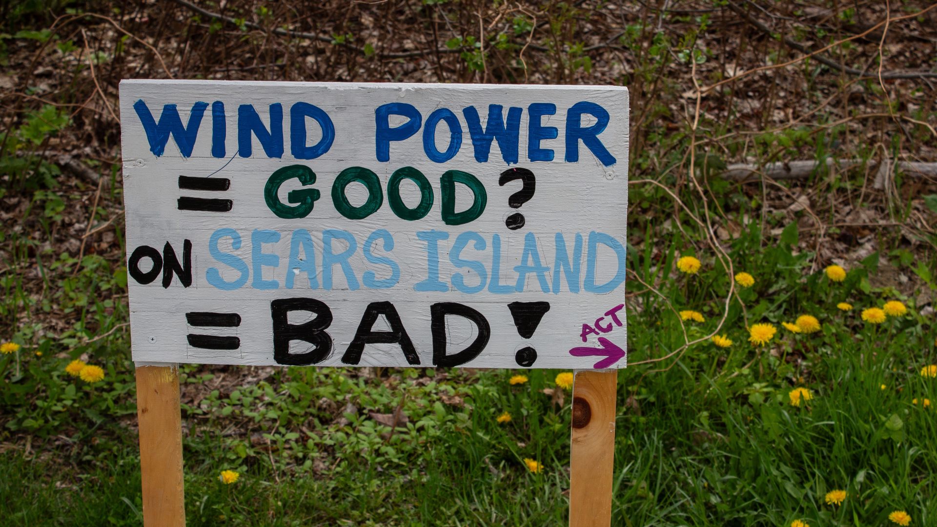 A sign that reads Wind Power equals Good question mark on sears island equals bad exclamation point