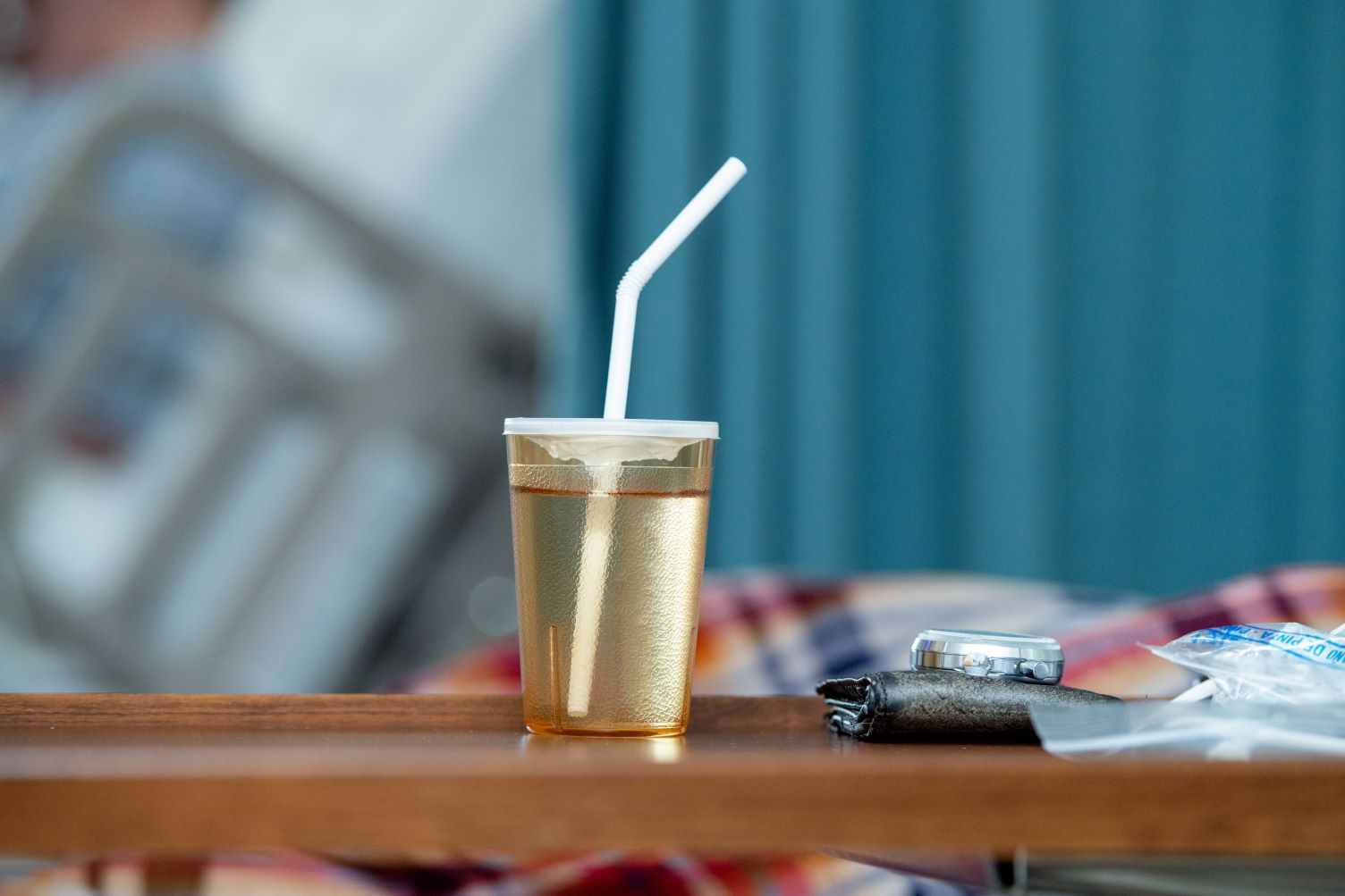 A cup filled with juice sits on an end table.