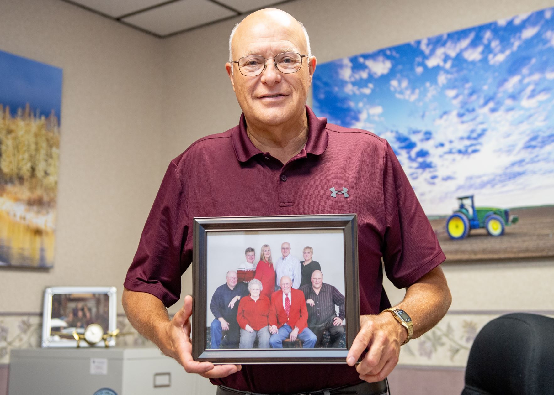 Phil Cyr holding a family portrait.