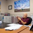 Phil Cyr sitting at his desk in his office.