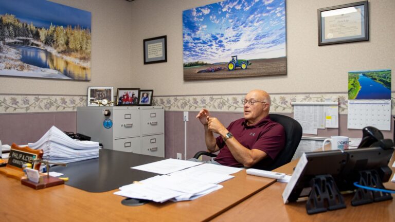 Phil Cyr sitting at his desk in his office.