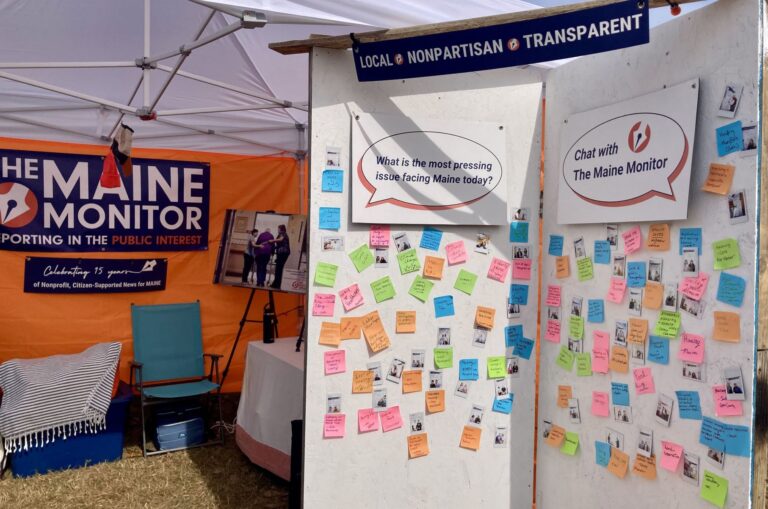 Sticky notes attached to two white boards at The Maine Monitor board answering the prompt of "What is the most pressing issue facing Maine today?"