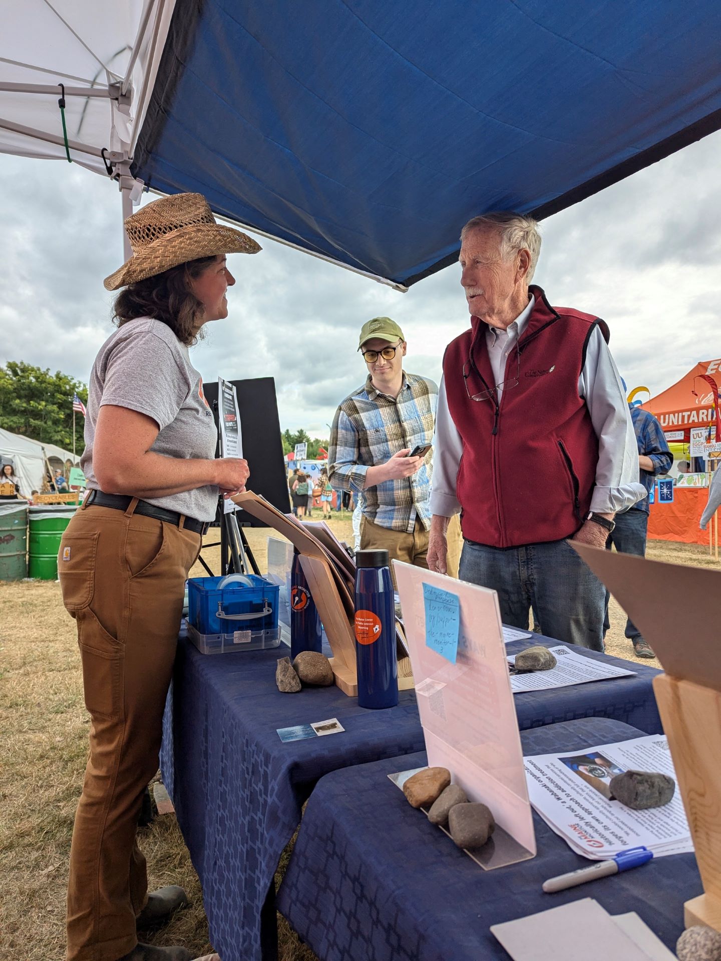 Micaela Schweitzer-Bluhm talks with Angus King at the newsroom's booth.