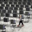 A woman walks through a row of empty voting stations.