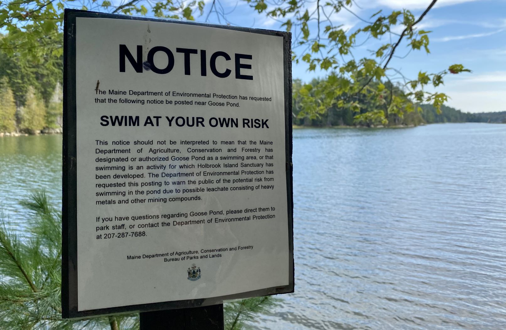 A swim advisory sign is posted alongside the pond at Holbrook.