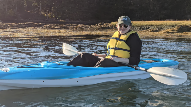 Annie Ropeik poses for a photo while sitting in a kayak.