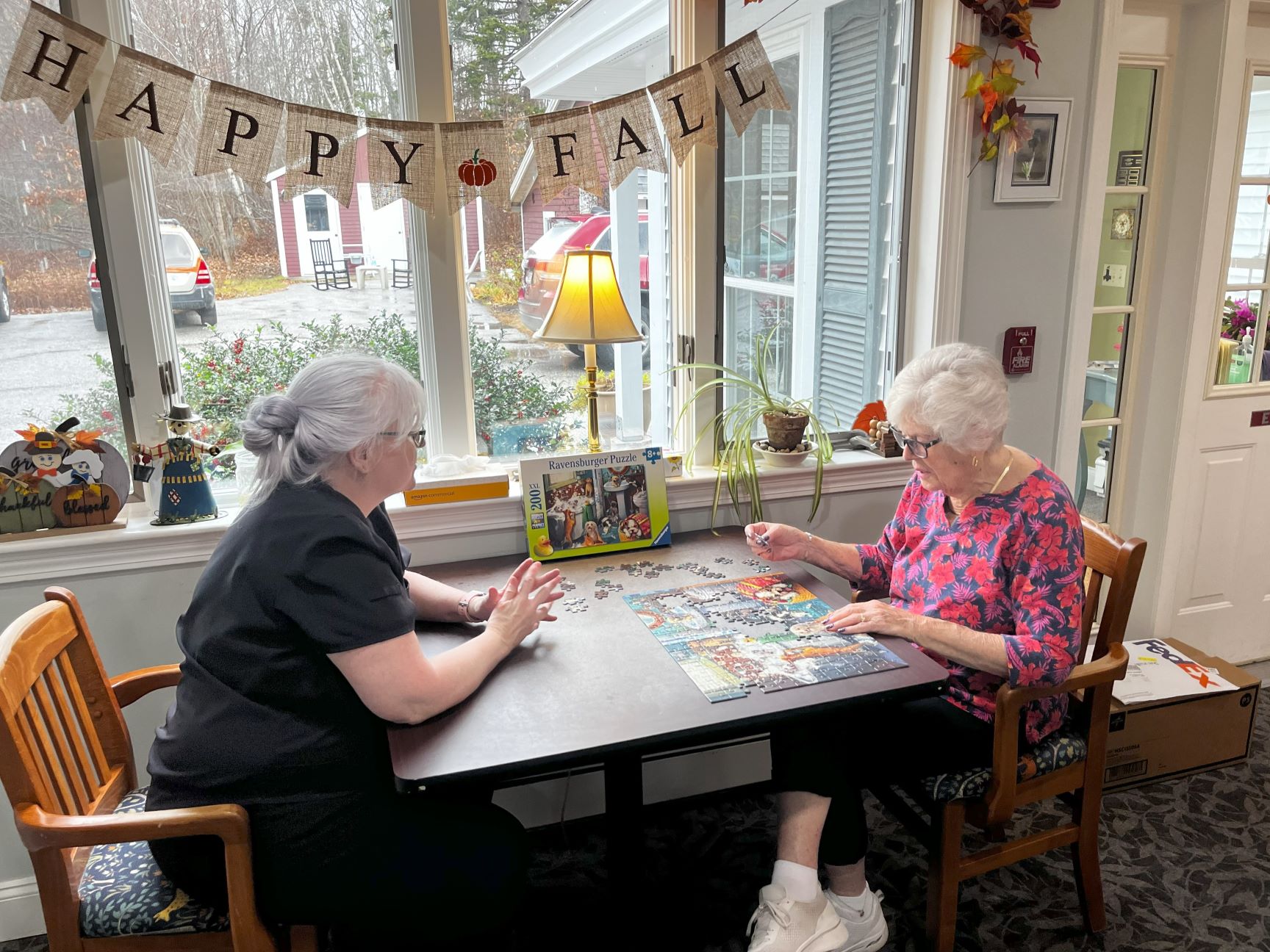 Two women completing a puzzle.