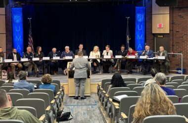 a panel of recovery council members listen to a speaker.