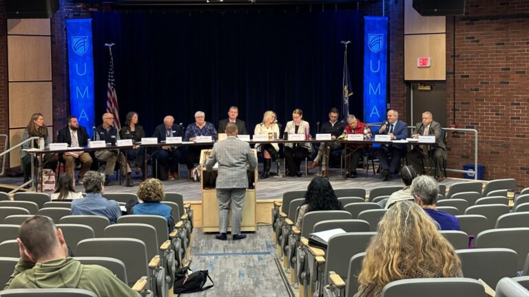 a panel of recovery council members listen to a speaker.