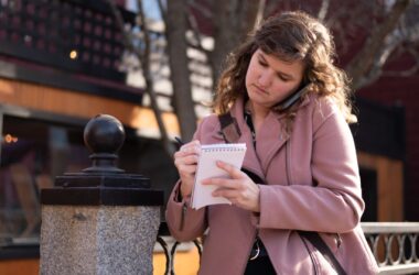 Maine Monitor reporter Rose Lundy jots down notes while on a phone call.