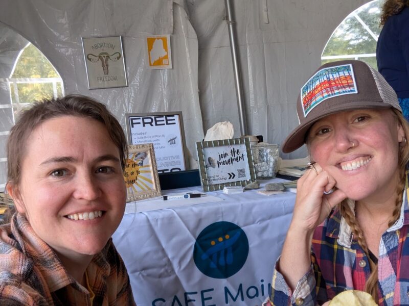 SAFE Maine workers pose for a selfie while tabling at the Common Ground Fair.