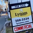 a commercial real estate for sale sign seen in the grass.