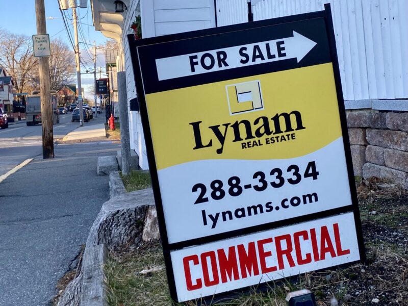 a commercial real estate for sale sign seen in the grass.