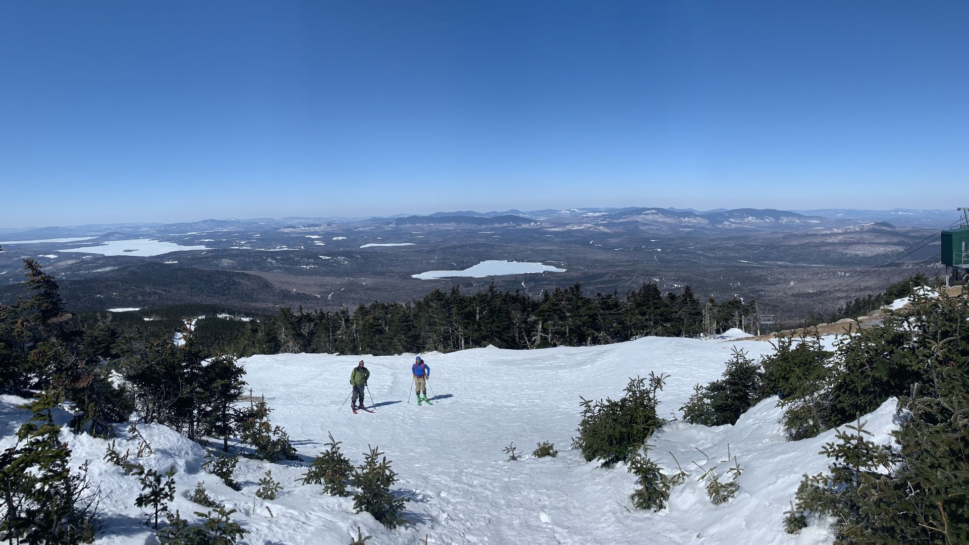 skiers on top of a mountain.