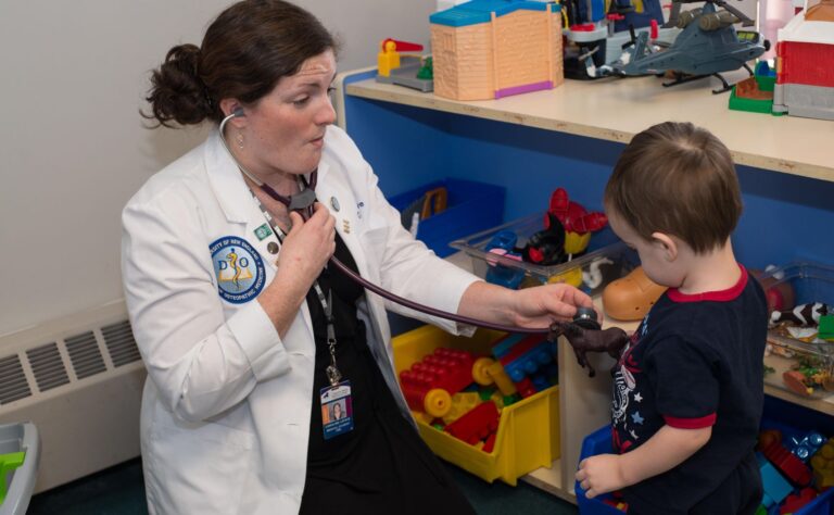 a pediatric student uses a stethoscope on a young child.