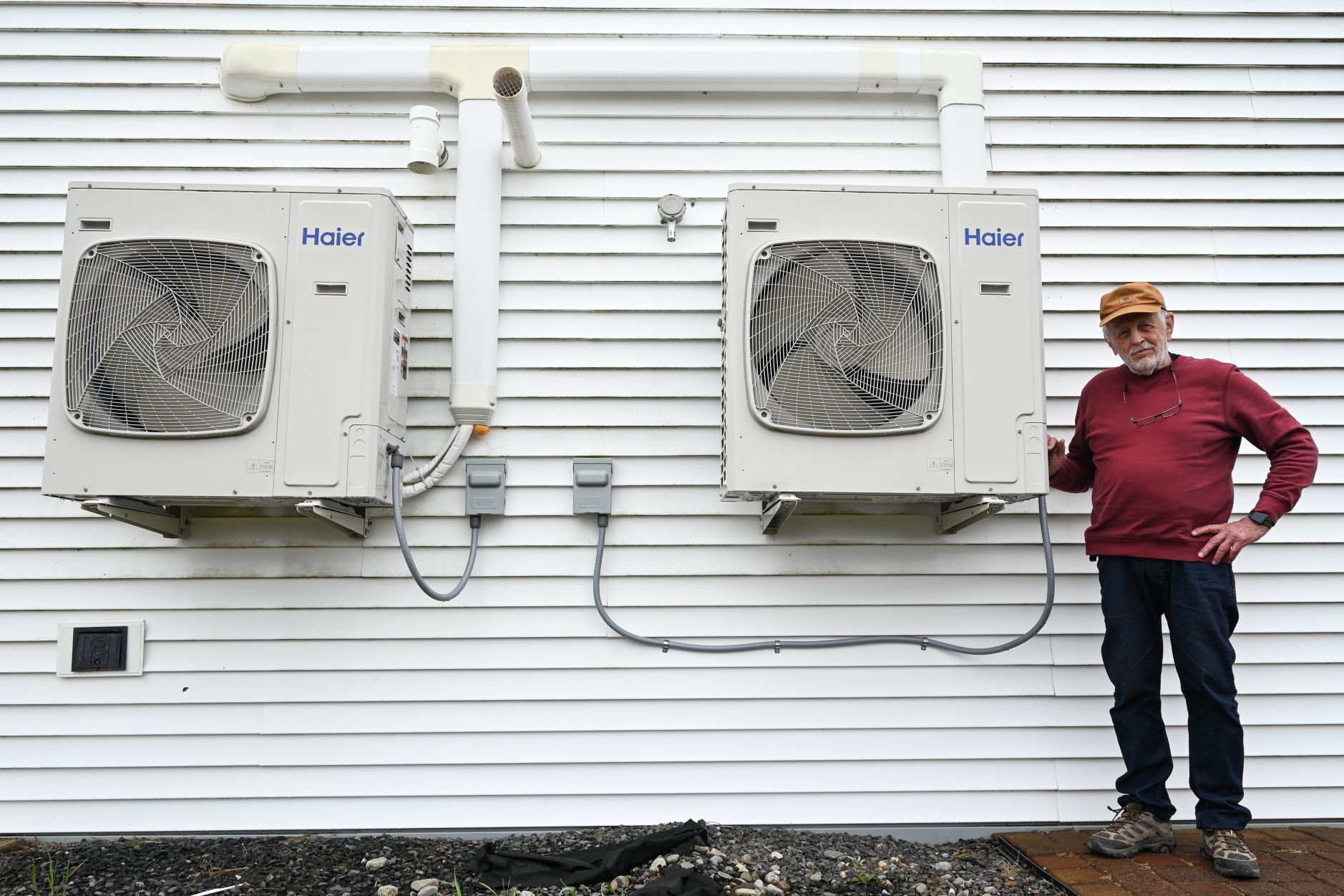 Dave Whittemore stands next to heat pumps.