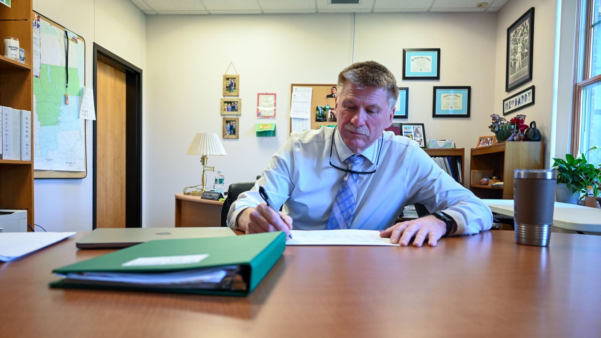Mark Campbell looking at papers on a desk.