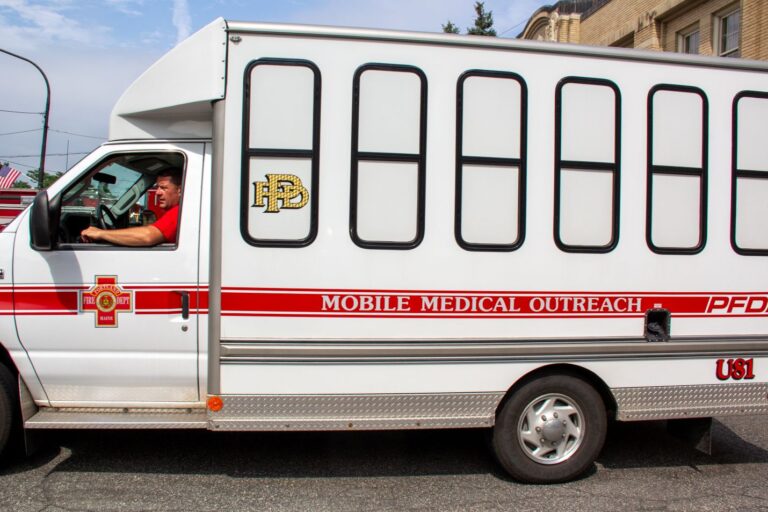 A paramedic sitting in the driver's seat of an outreach van.