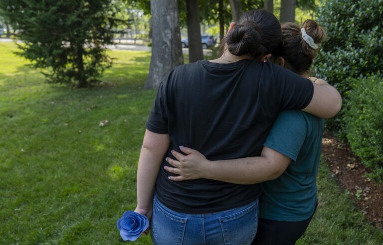 a mother and daughter embrace.