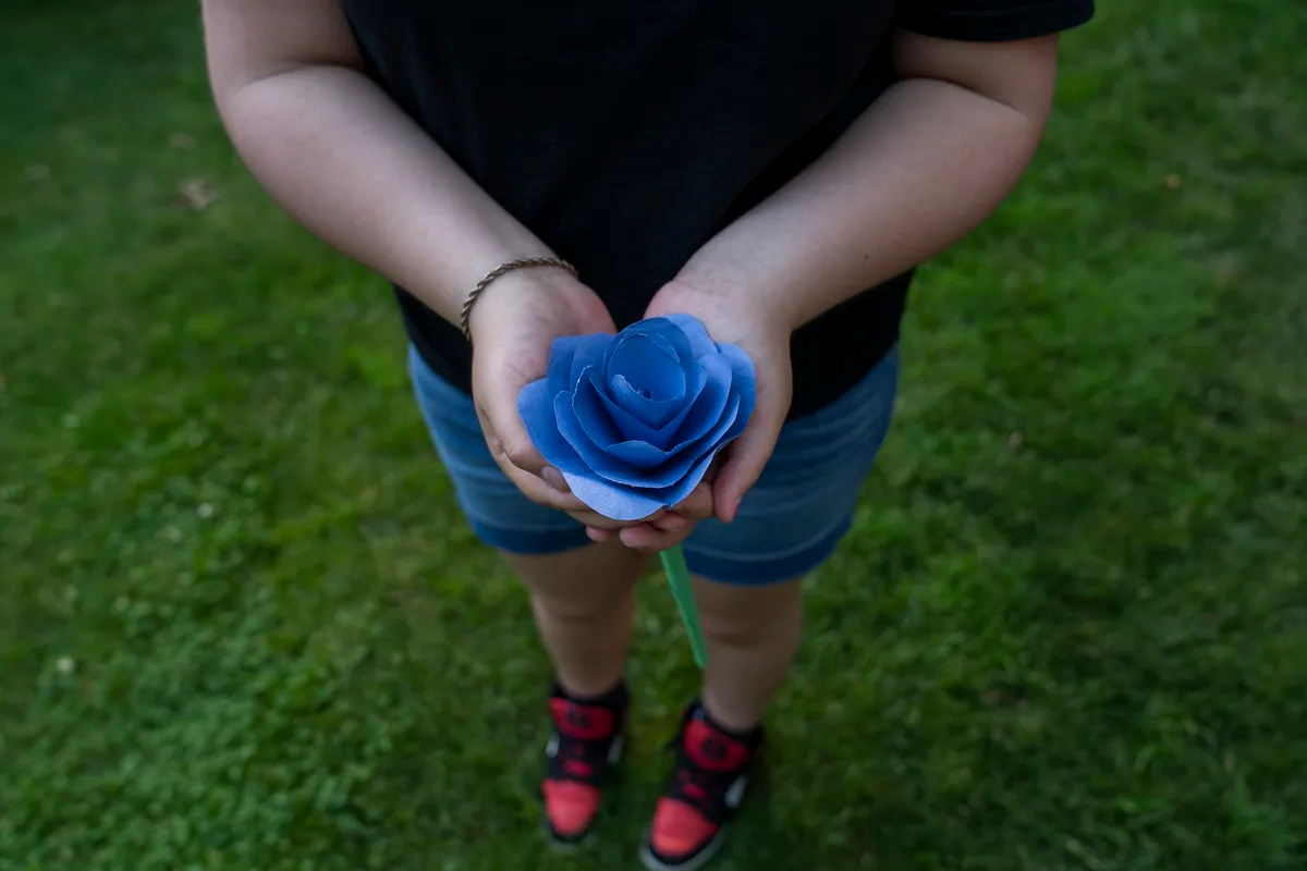 Yori holds a blue flower she made.