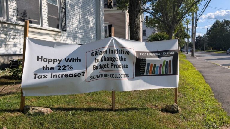 banner announcing a petition drive regarding the town budget.
