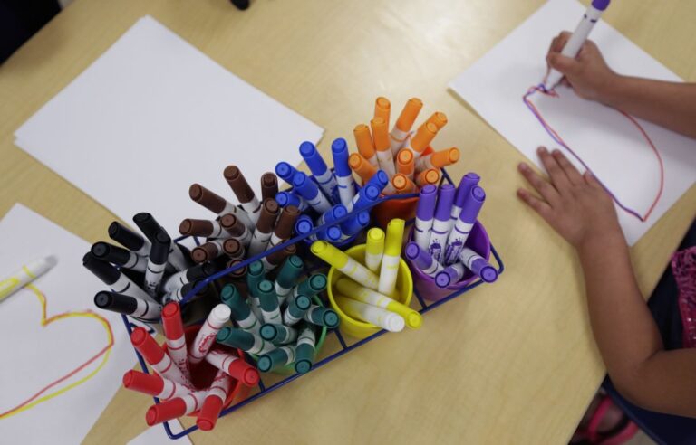 a preschool student draws an oval.