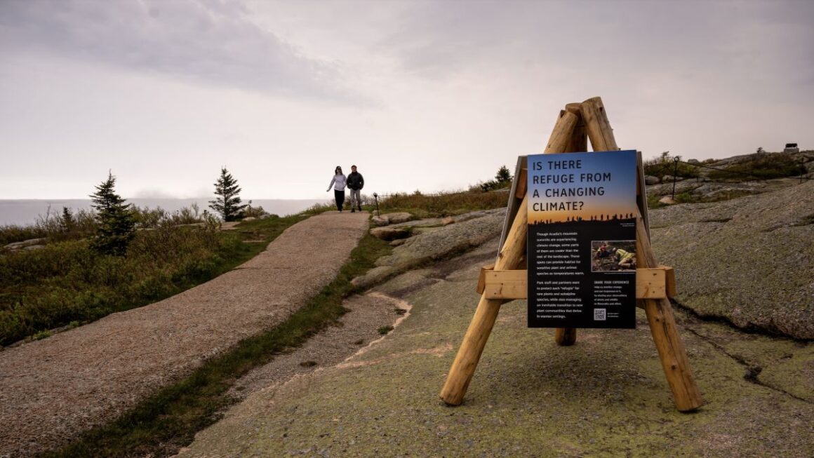 a sign about climate change on top of cadillac mountain.