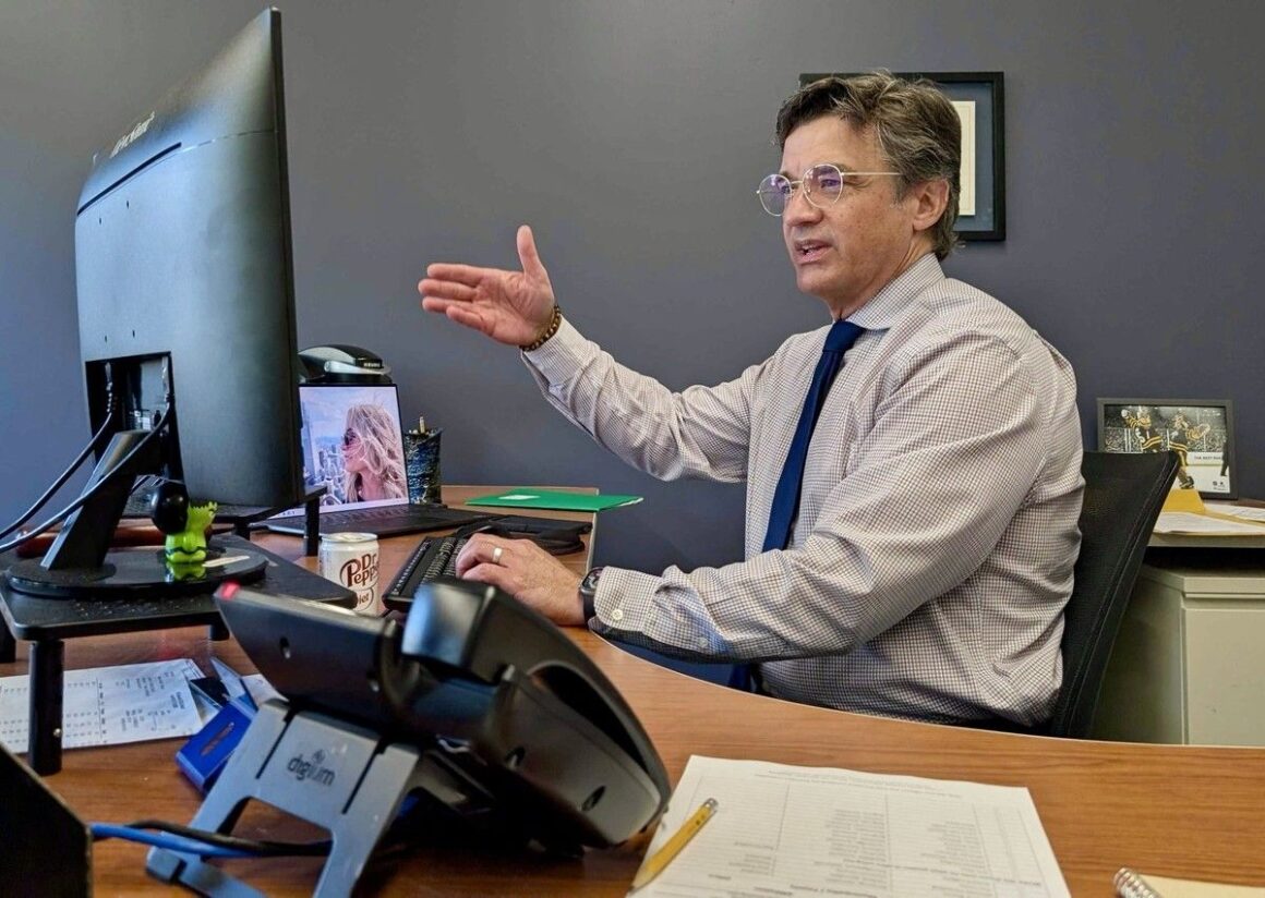 Anthony Wilson sitting behind his desk.