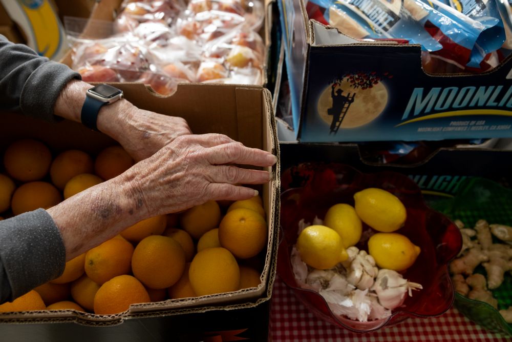 a hand organizes donated produce.