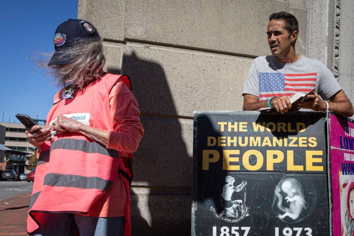 A man protests with a sign outside of a Planned Parenthood facility.