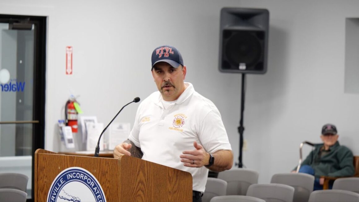 Jason Frost speaks at a podium.