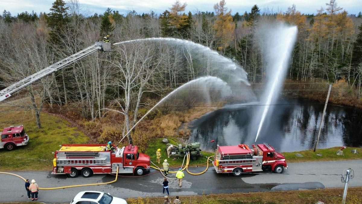 water spraying among the trees during a fire department training event.