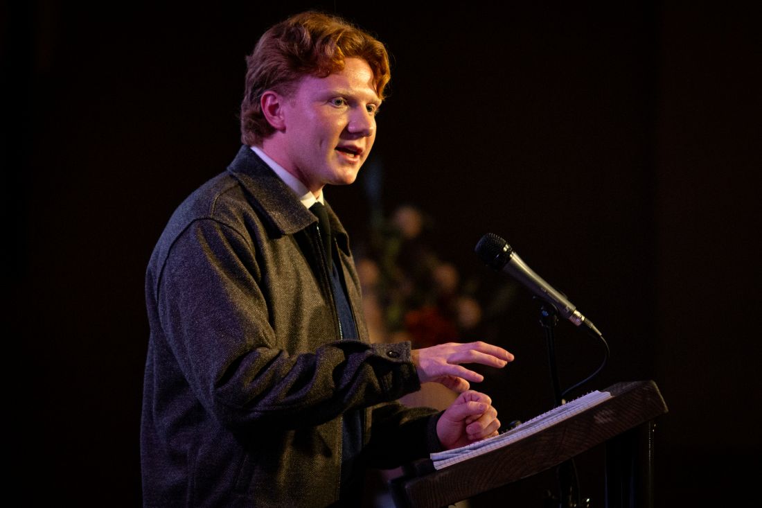 Zak Asplin speaking at a podium.