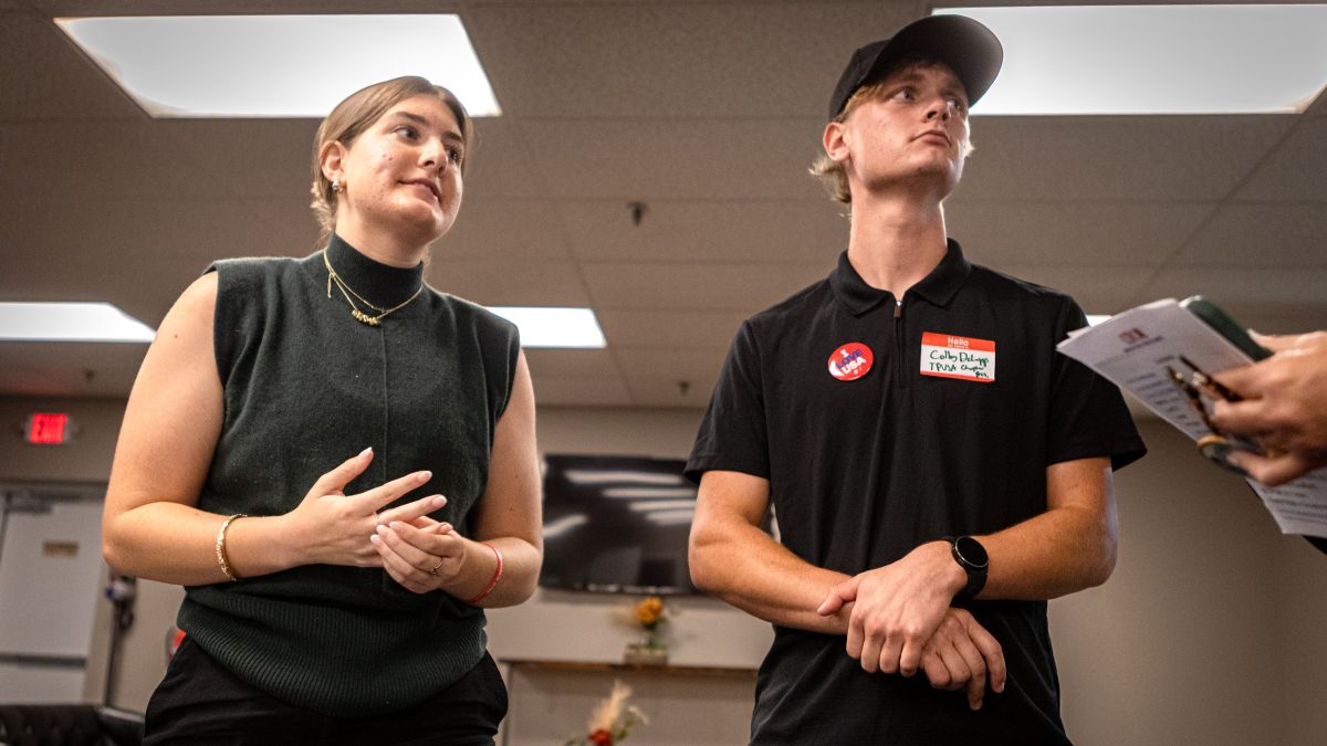 a young woman and man speaking with an individual (not pictured).