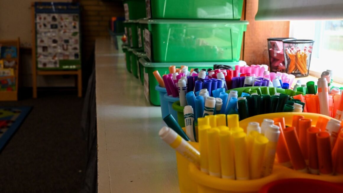 markers on a shelf in a classroom.