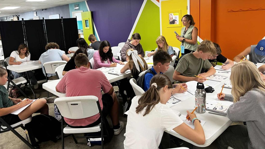 students sitting at tables working on an assignment.