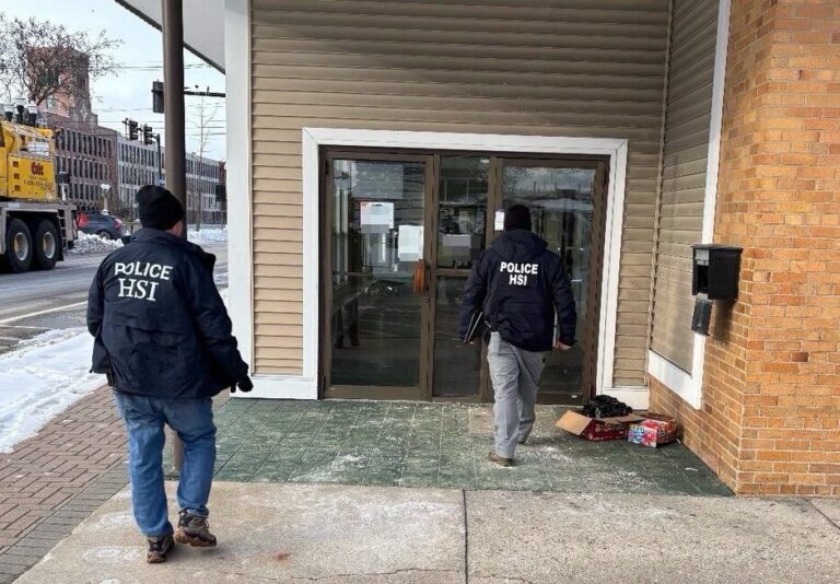 Federal agents walking up to a building.