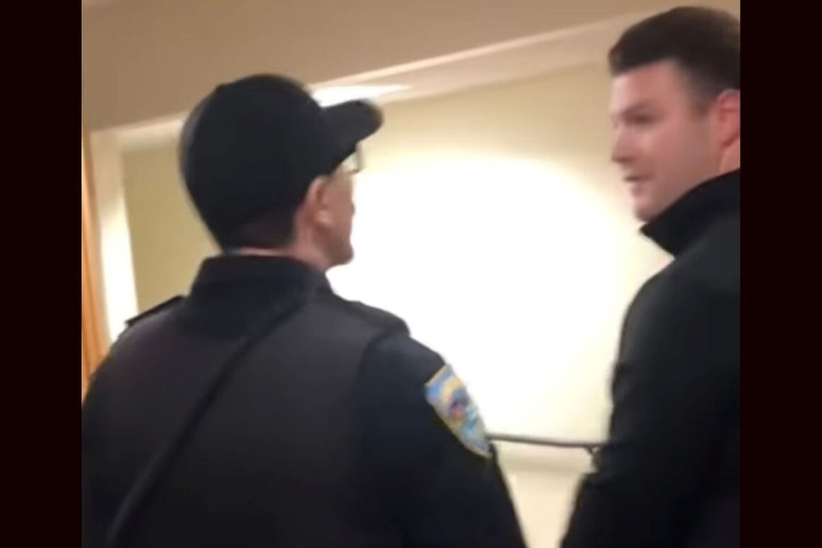 Trevor Savage speaks with a police officer.