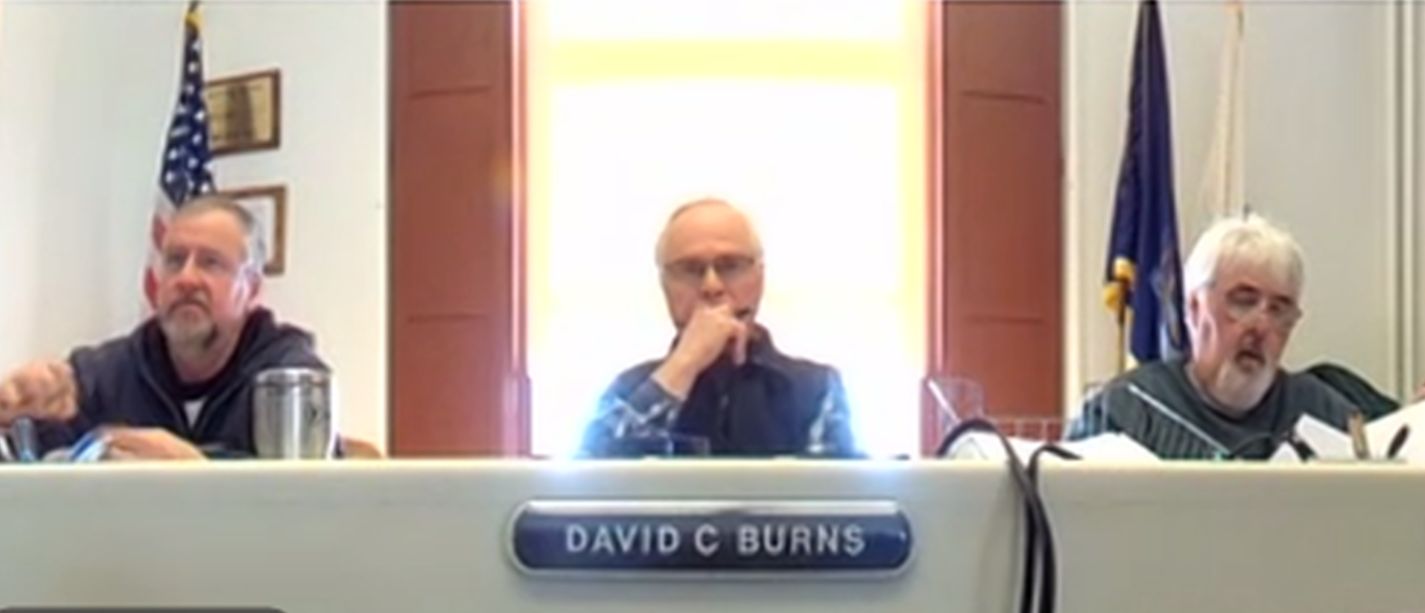 commissioners listen during a meeting.