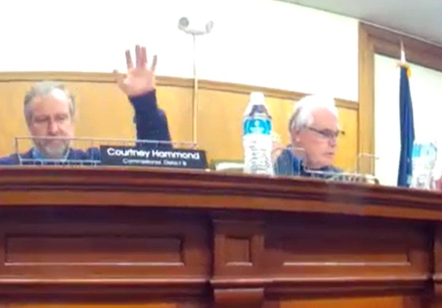 two of the washington county commissioners sit during a meeting.