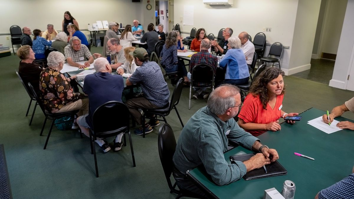 people gather at tables during a breakout session at a listening tour stop.