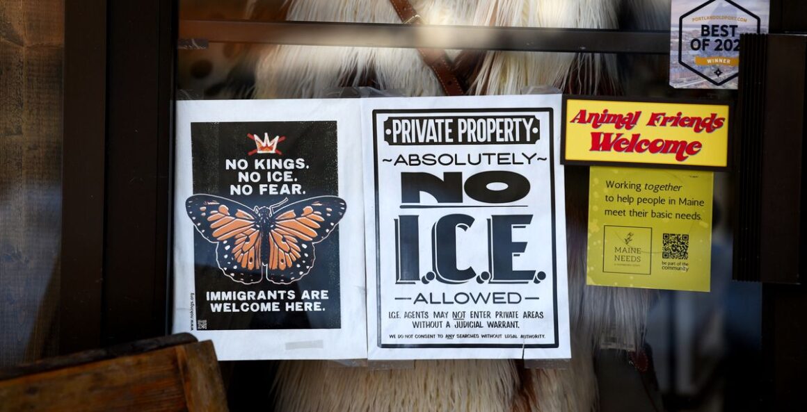A "No ICE" sign hangs in the window of a business.